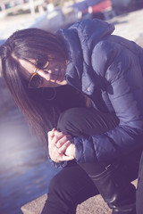 Young woman smiles sitting on the dock at the port