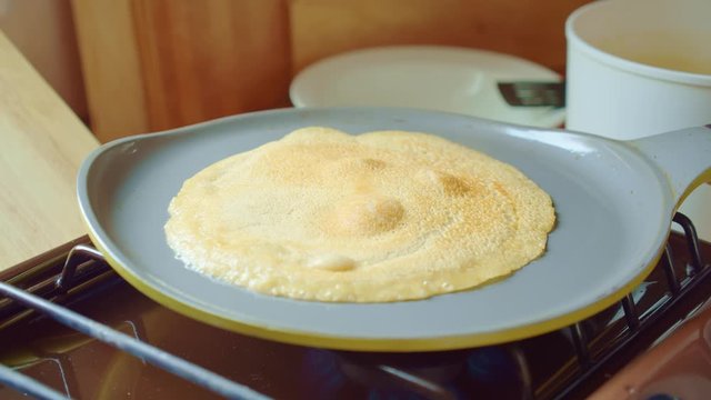 Pancake fried on gray pan in kitchen. Steam comes. Home cooking. Close up.