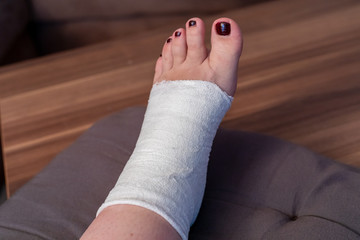 female is wrapping his Foot injury with bandage