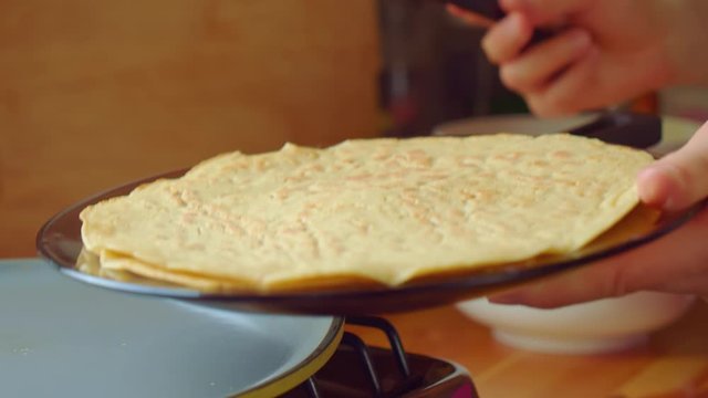 Cook put baked delicious pastil cake spatula from pan to glass plate. Close up.