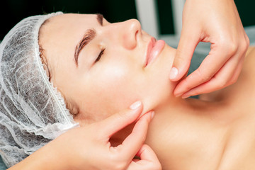 Fototapeta na wymiar Chin massage of woman young woman during face massage at beauty salon.