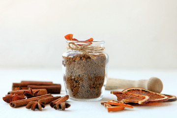 Cinnamon sticks, dried oranges and star anise with brown sugar bottle with shallow depth of field on white background. Baking ingredients