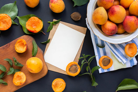 card mockup with ripe apricots on dark  table with leaves. evelope