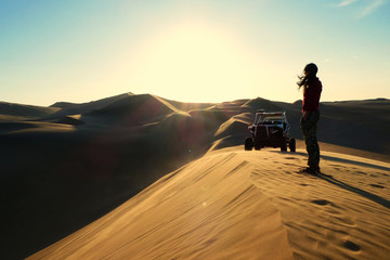 mujer en el destiero en atardecer junto a un buggy