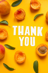  apricots and leaves with paper words. Thank you on orange paper