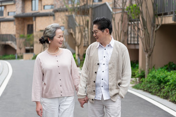 Fototapeta premium An Asian elderly couple walking in the community