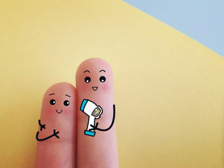 Two fingers are decorated as two person. Both of them are checking temperature.