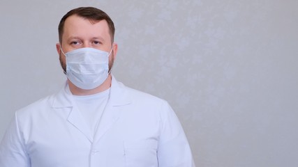 man in a protective mask and a white shirt looks at the camera, close-up. Hygiene concept. prevent the spread of germs and bacteria and avoid infection with the crown virus. copy space