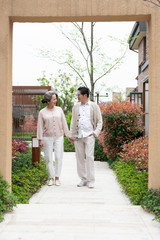 An Asian elderly couple walking in the community