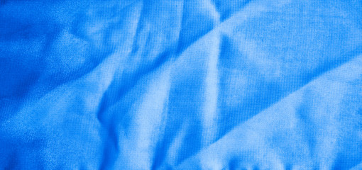Texture of classic blue Wrinkled Fabric. Trendy color of clothes. Close-up.
