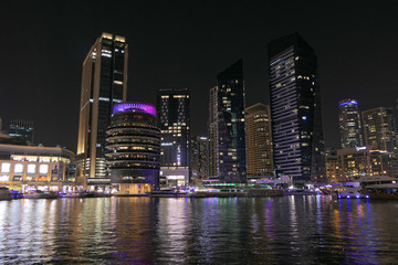 Fototapeta na wymiar Dubai skyscrappers in the night. Reflection from the river.