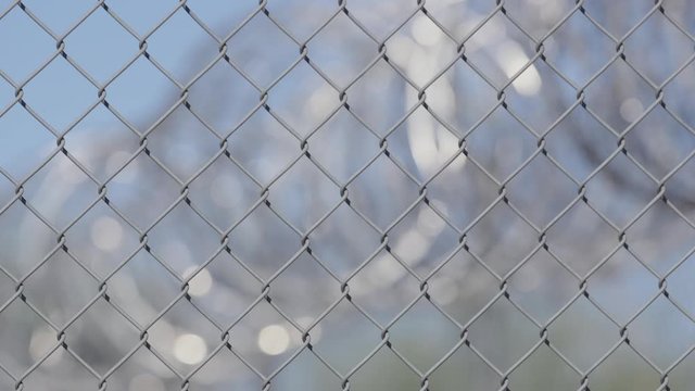 A fence outside an american jail with a focus pull to concertina wire