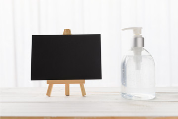 Stay home  protection from  coronavirus epidemic(COVID-19),black board and hand sanitizer bottle on white wood background