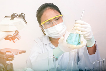 scientist working at the laboratory,Focused young life science professional pipetting solution into...