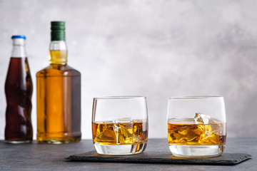 Glass with whiskey and ice cubes
