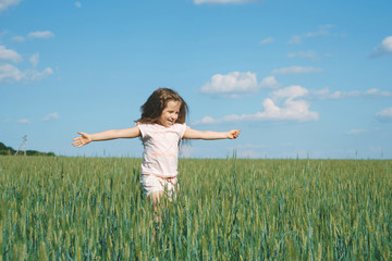 Naklejka na ściany i meble happy girl running in field