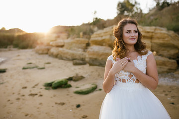 Fototapeta na wymiar Happy young bride woman in white dress running, have fun on clean sandy beach waves of azure sea or ocean on sunset, summer vacation at water. Wedding rest, relax honeymoon concept.