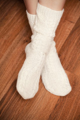 Fototapeta na wymiar pair of knitted woolen socks on woman's feet