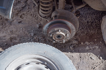 A broken wheel lies next to the machine. Old wheel hub. Emergency situation. breakdown on the road. Urgent repair.