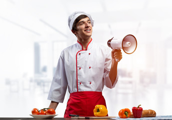 Young chef standing with megaphone in hand