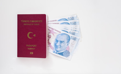Turkish passport and a bunch of 100 Turkish Lira (TRY) banknotes isolated on white background