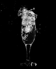 Splashes and drops of water in a glass are isolated on a black .
