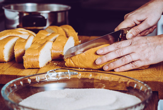 Persona preparando torrijas caseras con pan leche, azucar y canela para semana santa