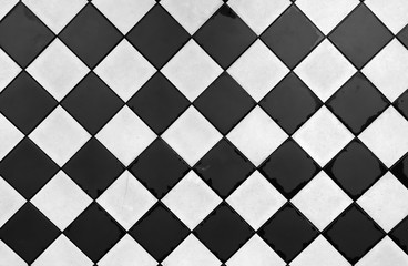 Vintage backdrop in black and white. Old tarnished tiles in an old fashioned classy pattern.