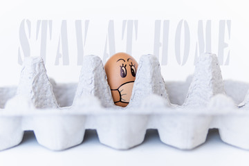 Egg in a tray with doodle face wearing medical mask. Conceptual image of stay at home during Corona virus quarantine