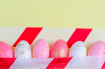 Easter eggs under barrier tape on yellow background, a concept of Easter during quarantine due to the coronavirus pandemic