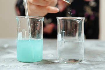 Glasses with colorful liquids for beauty products. Scientist prepare organic raw materials by hand. Quarantine work at home.