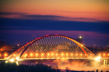 Fototapeta na wymiar Illumination of Bugrinskiy bridge on the sunset, Novosibirsk, Siberia