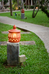 a glowing lantern in the evening by the path in the green Park om. evening