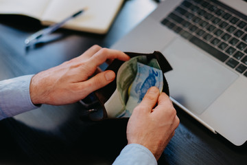 A businessman runs out of money. Checks a leather wallet against 