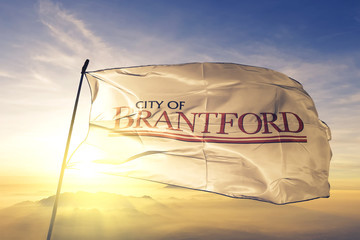 Brantford of Ontario of Canada flag waving on the top sunrise mist fog