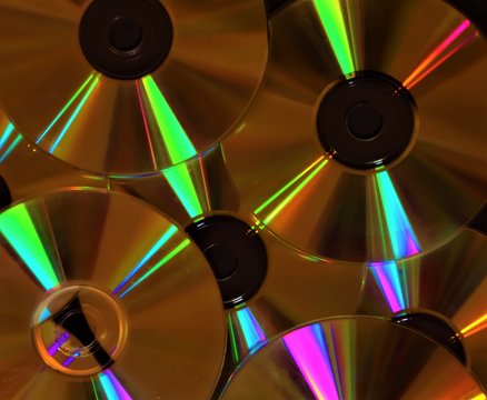 Multiple CDs DVDs discs on pile closeup