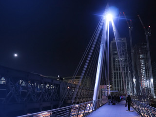 Evening walk at the  Hungerford Bridge and Golden Jubilee Bridges in London during Winter in the capital of Great Britain.