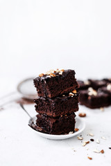 Chocolate brownie with nuts on paper on white background