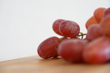 rote Weintrauben-Nahaufnahme und auf einem Küchenbrett