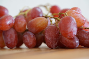 rote Weintrauben-Nahaufnahme und auf einem Küchenbrett
