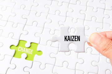 The kaizen word on white jigsaw go to replace change word on green gap - idea answer concept.