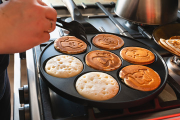 rosy pancakes on a frying pan. The process of cooking food