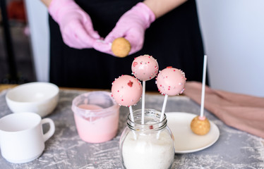 The pastry chef makes dessert on a stick. Cake pops. Chocolate cream for dessert, creation process.