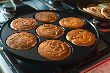 rosy pancakes on a frying pan. The process of cooking food