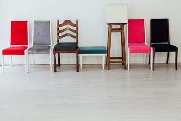 different multicolored chairs in the interior of the white room