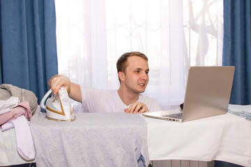 a young guy at home on self-isolation works remotely and is engaged in ironing.