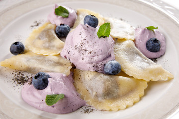 Blueberry cream dumplings on a white plate.