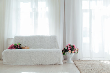 white sofa with flowers in the interior of the room - obrazy, fototapety, plakaty