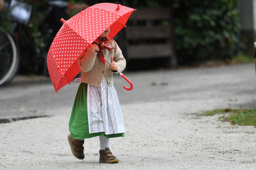 Ein kleines Mädchen in Trachtenkleidung mit Regenschirm - A little girl in traditional clothes...