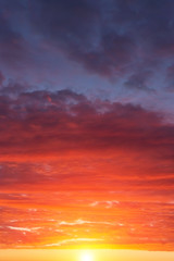 Naklejka premium Epic dramatic sunset, sunrise red orange sky with clouds, sun and sunlight